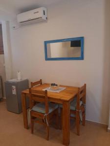 a wooden table with two chairs and a mirror at Temporario Necochea 2 corrientes in Corrientes