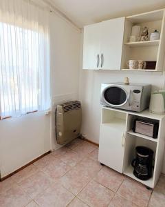 una pequeña cocina con microondas y ventana en Los Trineos, en Ushuaia