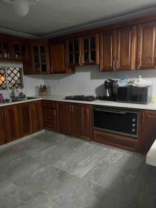 uma cozinha com armários de madeira e um forno de fogão preto em Villa Gordon em Santa Cruz de Barahona