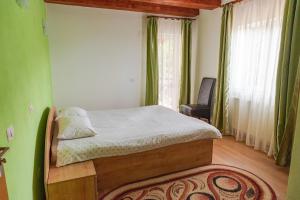 a bedroom with a bed in a room with green walls at Casa Negru Vodă Breaza in Breaza
