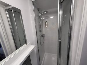 a bathroom with a shower with a glass door at Nottingham Forest Rd, Short Stays in Nottingham
