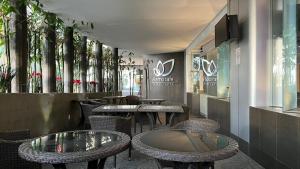 um restaurante com mesas, cadeiras de vime e janelas em NewPort Love Hotel em Cidade do México