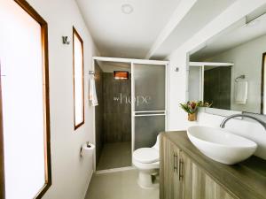 a bathroom with a sink and a toilet at Aparta Hotel Downtown Guatapé in Guatapé