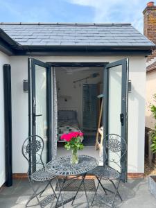 einen Tisch mit einer Blumenvase auf einer Terrasse in der Unterkunft The Whitstable, Tankerton Bolt Hole in Kent