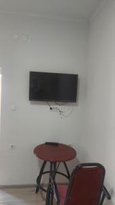 a table with a chair and a television on a wall at Restoran Ruža in Jablanica