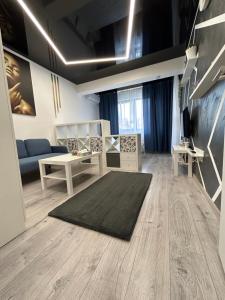 sala de estar con sofá azul y alfombra en Perla Home - Studio 9 en Popeşti-Leordeni