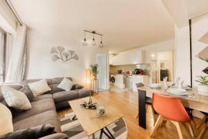 ein Wohnzimmer mit einem Sofa und einem Tisch in der Unterkunft Superbe appartement 5P in Châtillon
