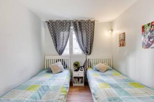 2 Betten in einem Zimmer mit Fenster in der Unterkunft Superbe appartement 5P in Châtillon