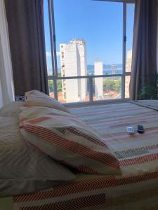 uma cama com vista para a cidade a partir de uma janela em Lapa no Rio de Janeiro