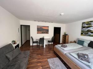 a bedroom with a bed and a table and chairs at Helle FeWo am Waldrand - mit Balkon, Pool & Sauna in Freyung
