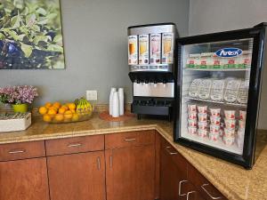 a refrigerator filled with drinks and a basket of fruit at Broadway Inn Conference Center in Missoula