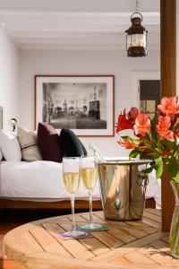 2 copas de vino en una mesa de madera en la sala de estar en Villa Barranco by Ananay Hotels en Lima