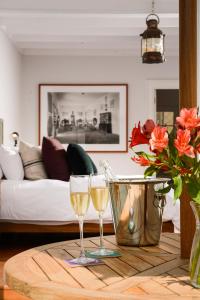 リマにあるVilla Barranco by Ananay Hotelsの木製テーブルの上に置かれたリビングルームでのワイン2杯