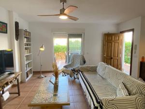 uma sala de estar com um sofá e uma mesa em Adosado en playa Vera,3 piscinas em Vera