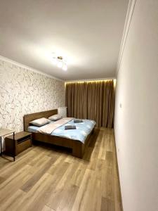a bedroom with a bed and a wooden floor at Chornovola Apartment Липинського 28 in Lviv