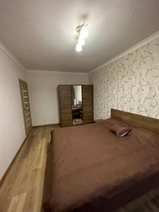 a bedroom with a large bed and a mirror at Chornovola Apartment Липинського 28 in Lviv