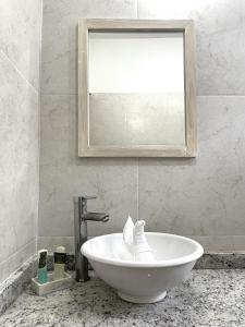 a bathroom with a white sink and a mirror at Hotel Inkanto in Mahahual