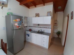 a kitchen with a refrigerator and a sink at Hospédate en Nuestra Cabaña en Termas de Rio Hondo y Disfruta de unas Confortables y Relajantes Vacaciones in Termas de Río Hondo