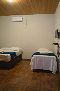 Habitación con 2 camas y calentador en la pared en Pousada Capim Dourado Ponte Alta en Ponte Alta do Tocantins