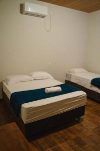 1 dormitorio con 2 camas y toallas. en Pousada Capim Dourado Ponte Alta en Ponte Alta do Tocantins