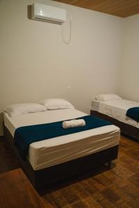 a bedroom with two beds with towels on them at Pousada Capim Dourado Ponte Alta in Ponte Alta do Tocantins