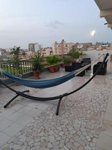 a hammock on a balcony with a view of a city at Hann Mariste in Dakar