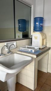 a kitchen counter with a sink and a machine on it at Hospedagem Casa da Rê in Salto