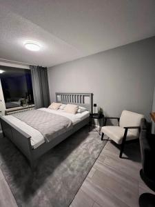 - une chambre avec un grand lit et une chaise dans l'établissement KELLER APARTMENT I 106 Kniebis, à Freudenstadt
