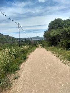 a dirt road with a utility pole on the side at Casa al pie de la montaña in San Roque