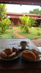 托坎廷斯州蓬蒂阿爾塔的住宿－Pousada Capim Dourado Ponte Alta，餐桌,带两盘食物和一杯咖啡的桌子