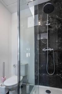 La salle de bains est pourvue de toilettes et d'une douche en verre. dans l'établissement La Teranga B avec salle de sport, à Rouen