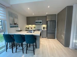 een keuken met een eiland met barkrukken erin bij 2 bedroom 2 bath Aquarius, Friday Harbour, Innisfil, Barrie in Innisfil