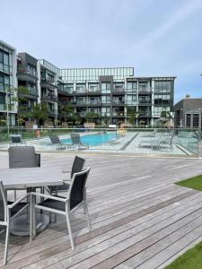 a patio with a table and chairs and a pool at 2 bedroom 2 bath Aquarius, Friday Harbour, Innisfil, Barrie in Innisfil