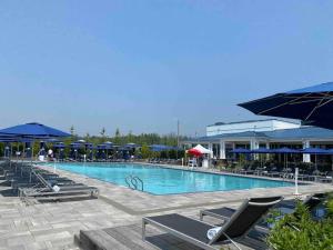 a large swimming pool with lounge chairs and umbrellas at 2 bedroom 2 bath Aquarius, Friday Harbour, Innisfil, Barrie in Innisfil