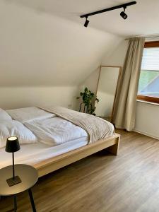 a bedroom with a bed and a table and a window at Ferienwohnung am Bollrich in Goslar