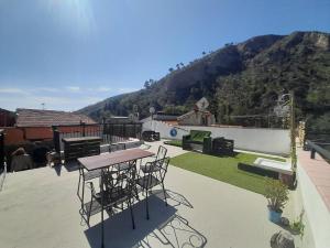 d'une terrasse avec une table, des chaises et une montagne. dans l'établissement Apartment Coffee Time, à Cisano sul Neva