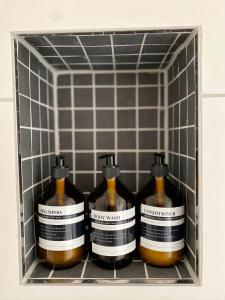 four bottles of soap in a shelf in a bathroom at Ferienwohnung am Bollrich in Goslar