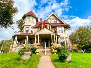 una casa vieja con flores delante en The Eden Hall Inn, en Charlottetown