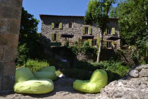 dois sacos de feijão verde em frente a um edifício em Maison Sous Le Pont em Meyras