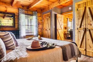 a hat on a bed in a room with wooden walls at Couples retreat *location*hot tub*fire pit* in Pigeon Forge