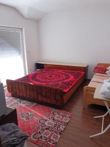 ein Schlafzimmer mit einem großen Bett mit einer roten Bettdecke in der Unterkunft ENGIN APARTMENT in Struga