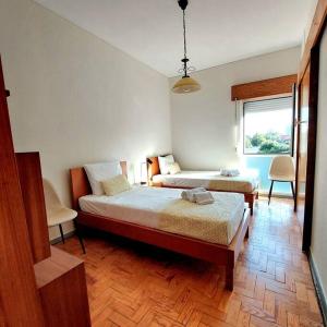 - une chambre avec 2 lits et une fenêtre dans l'établissement Oliva 50 - 4BR, Office and Balcony, à Lisbonne