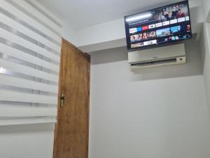 a room with a door and a tv on the wall at Apto 18 de 2 andares com 2 quartos in Montes Claros