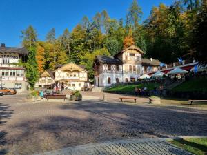 a large building in a town with people sitting on benches at Willa "KomaNcza" Szczawnica E-Apartamenty in Szczawnica