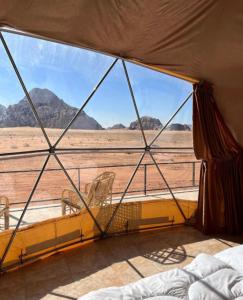 a tent with chairs and a view of the desert at Mira luxury camp in Wadi Rum