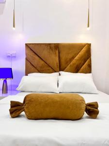 a bed with a brown headboard and white pillows at Luxury Shortlet Apartment LBS, AJAH in Lagos