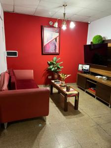 雷西斯騰西亞的住宿－Casa1，客厅设有红色的墙壁、沙发和桌子
