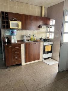 a kitchen with wooden cabinets and a stove at Casa1 in Resistencia