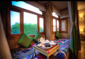 a room with a bed and a table with a tray of food at Hotel Jasmin Home in Jaisalmer