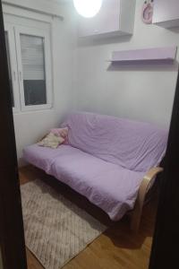a small bed in a room with a window at Apartments Luna Kumanovo in Kumanovo